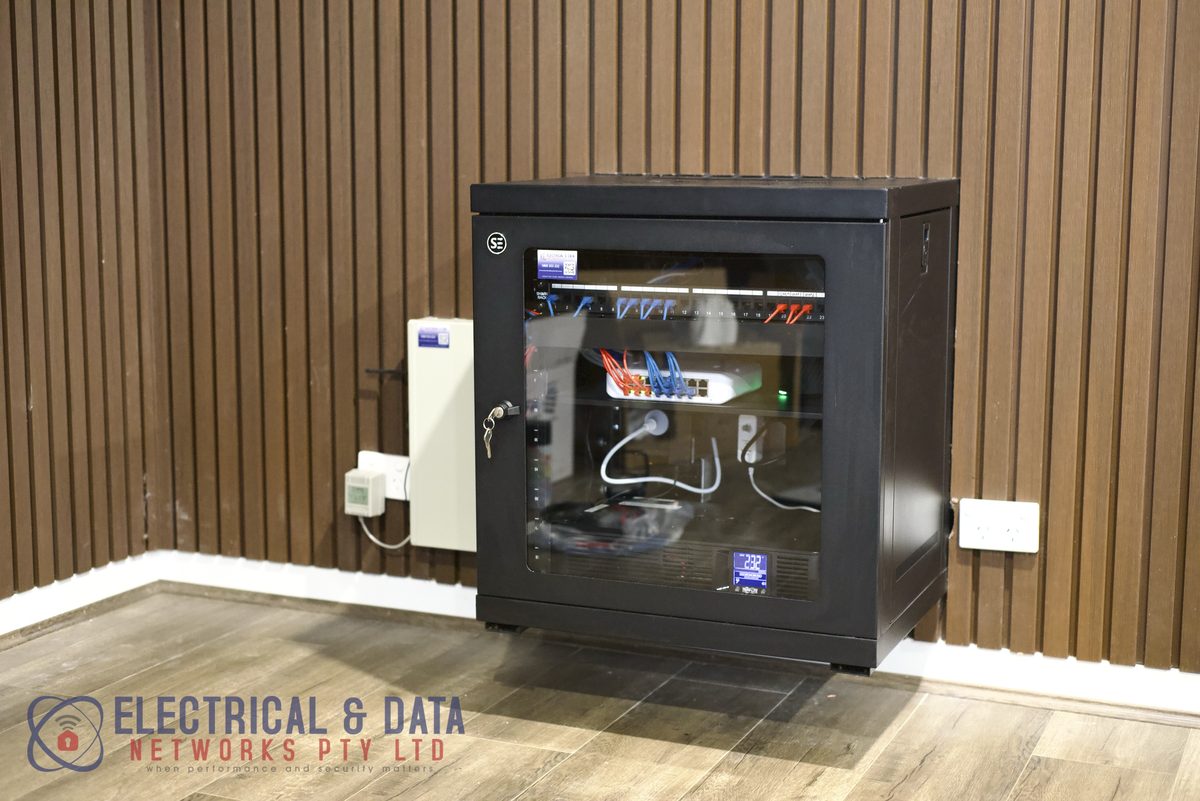 Wall-mounted communications cabinet neatly patched by EDN at Malwa Motor Group