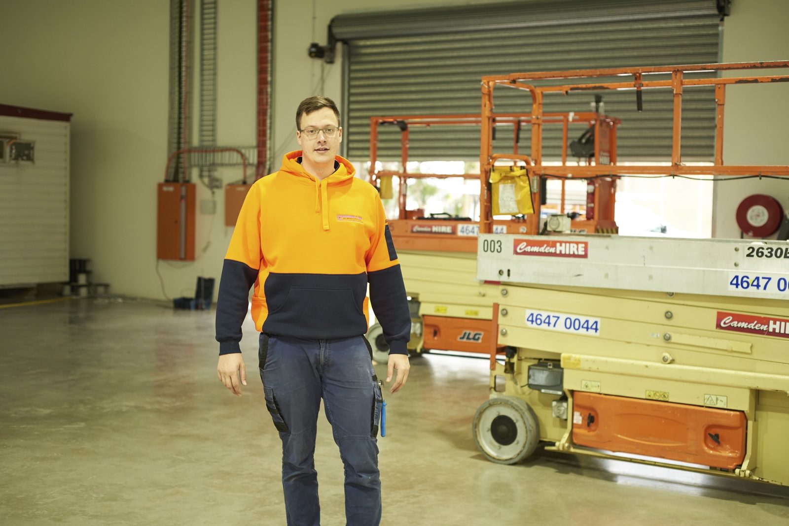 EDN team member with company-owned scissor lifts on a commercial warehouse site